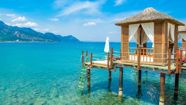 Wooden beach pavilions on the shore of a sandy beach - the Mediterranean coast, Beldibi, Antalya, Turkey